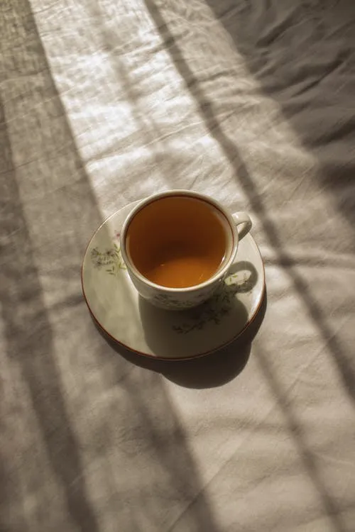 En kopp te ved et vinduskartet om morgenen med myk naturlig belysning
